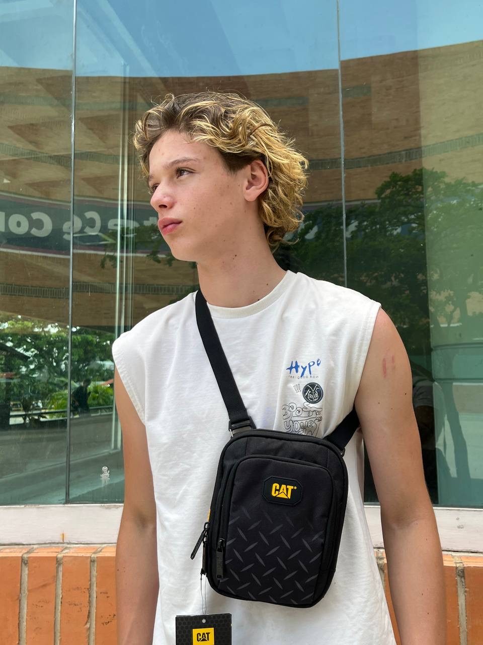 Bolso cruzado CAT con placa amarilla, estilo urbano