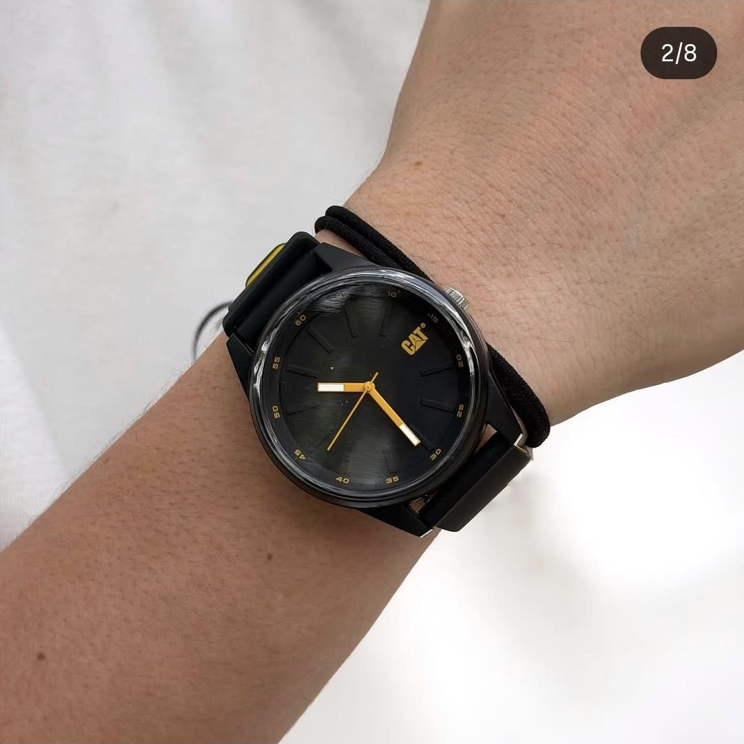 Reloj CAT negro con detalles amarillos en muñeca